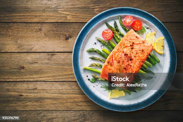 Grilled Salmon Garnished With Green Asparagus And Tomatoes Stock Photo - Download Image Now