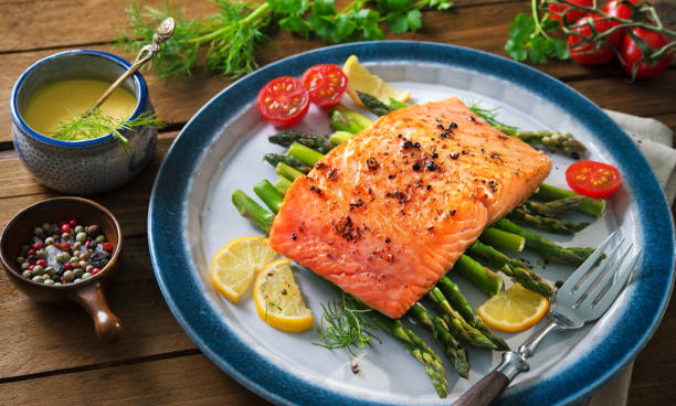 istock Grilled salmon garnished with green asparagus and tomatoes 935316794