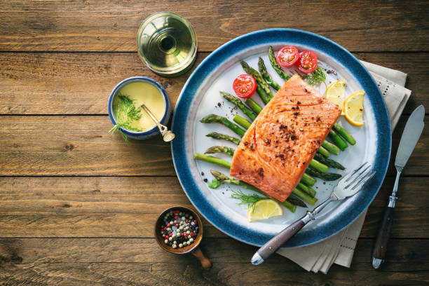 istock Grilled salmon garnished with green asparagus and tomatoes 935316812