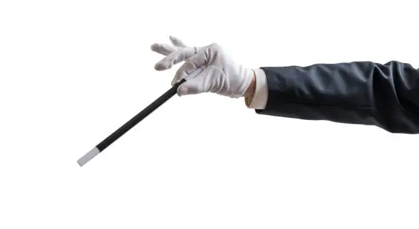 Magician hand is holding magic wand. Isolated on white background.