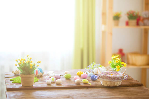 istock Colorful easter eggs and brushes on wooden table in home 935324158
