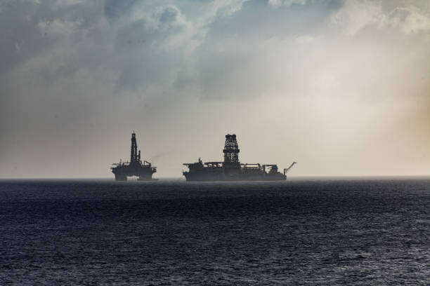 istock Floating Oil Rigs on Ocean in Sillhouette 935324760