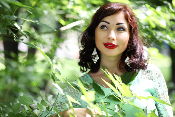 Beautiful woman modeling in front of a wall of leaves