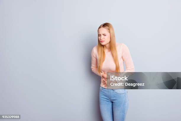 Portrait Of Sad Unhappy Upset Stressed Frustrated Depressed Crying Troubled Nervous Bad Negative Feeling Woman Touching Holding Tummy With Hands Isolated On Gray Background Copyspace Stock Photo - Download Image Now