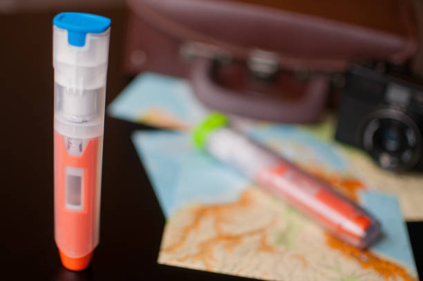 Epipen focal point with travel maps, suitcase and camera in background Epipen for allergies focal point with travel maps, suitcase and camera in background adrenaline stock pictures, royalty-free photos & images