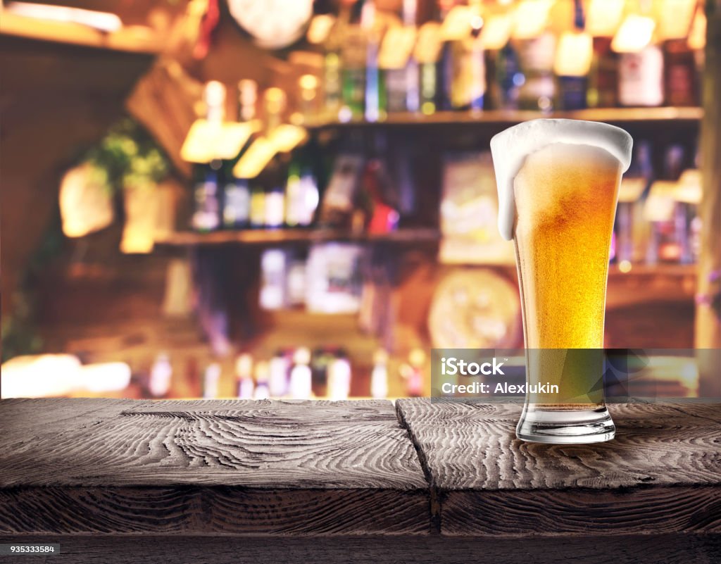 Glass of light beer on wooden board Glass of light beer on wooden board on the bar&#39;s background Bar Counter Stock Photo