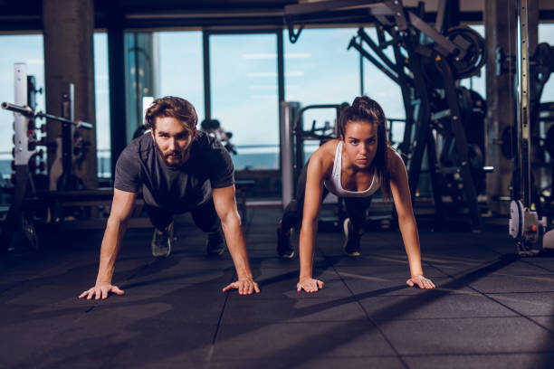 istock Young happy athletes exercising push-ups in a gym 935337380