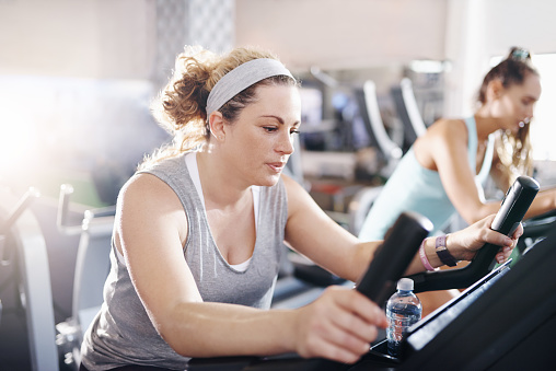 Shot of a mature woman working out on an exercise bike in a gym