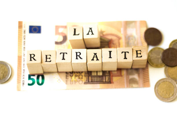 Wood Blocks Spelling "LA RETRAITE";  Euro Cash Wood Blocks Spelling “LA RETRAITE” (Retirement in French) on Top of Euro cash. White background with copy space. european union currency france number 50 coin stock pictures, royalty-free photos & images