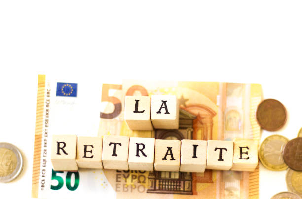 Wood Blocks Spelling "LA RETRAITE";  Euro Cash Wood Blocks Spelling “LA RETRAITE” (Retirement in French) on Top of Euro cash. White background with copy space. european union currency france number 50 coin stock pictures, royalty-free photos & images