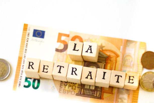 Wood Blocks Spelling "LA RETRAITE";  Euro Cash Wood Blocks Spelling “LA RETRAITE” (Retirement in French) on Top of Euro cash. White background with copy space. european union currency france number 50 coin stock pictures, royalty-free photos & images