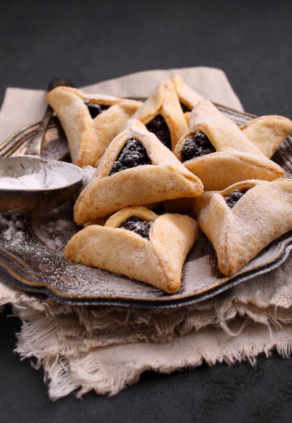 hamantaschen cookies com semente de papoula e risins e num prato de açúcar de confeiteiro - risins - fotografias e filmes do acervo