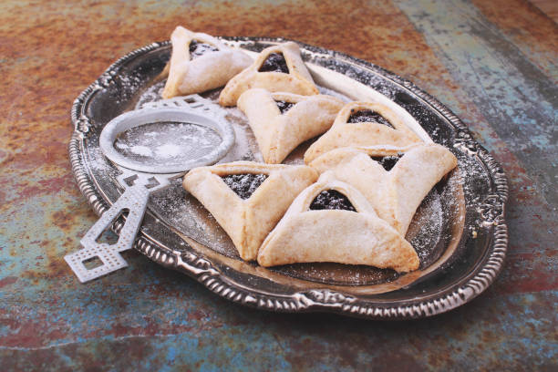 istock Hamantaschen cookies with poppy seed and risins and icing sugar on a plate 935346168