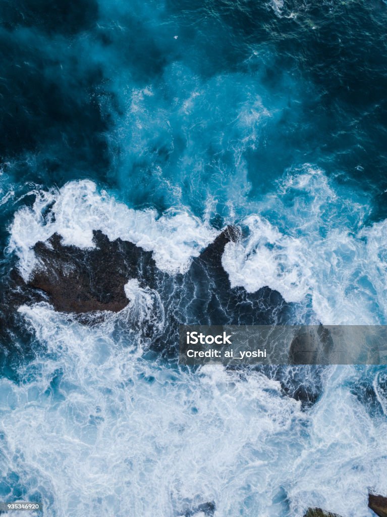 Water around rock Aerial view of water surrounding a big rock in the surface. Wave - Water Stock Photo