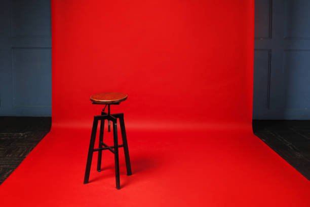 istock Wooden retro stool on red background. No one, free space on the right. 935350712
