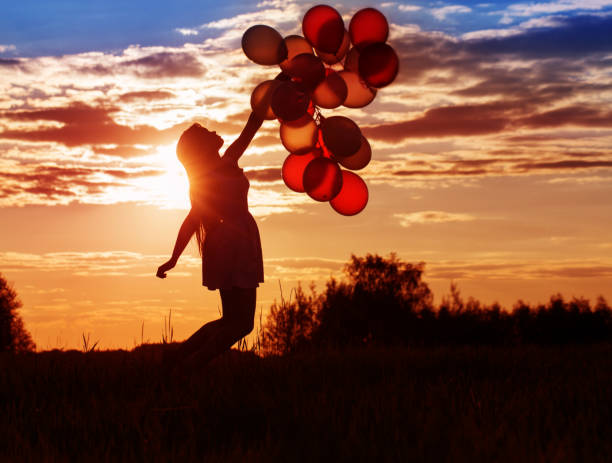 istock young women with balloons at sunset 935350720