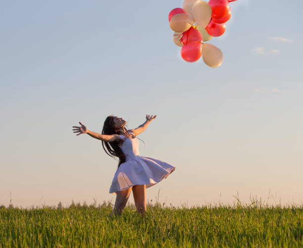 istock young women with balloons outdoor 935350736