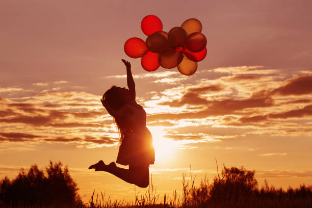istock young women with balloons at sunset 935350836
