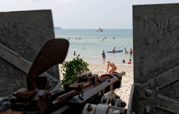 die kanone des zweiten weltkriegs am strand - world war ii battlefield landscape battle stock-fotos und bilder