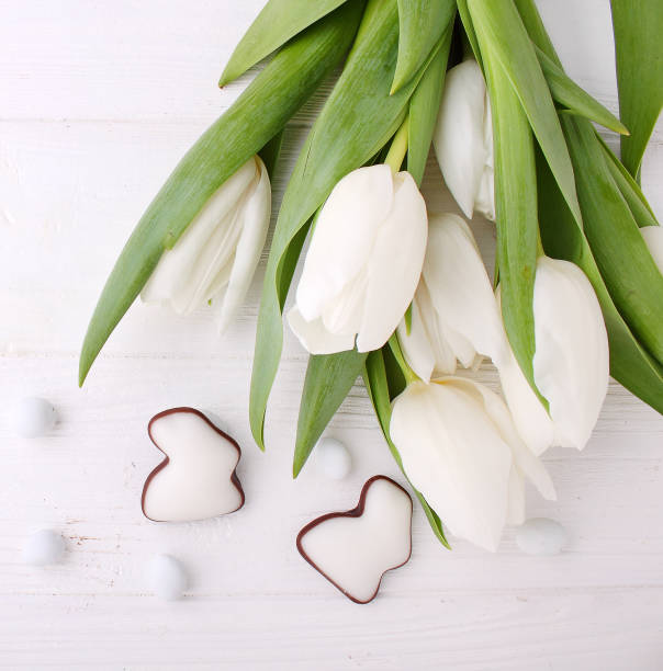 istock Sweets for celebrate Easter. White tulips, chocolate eggs 935354958
