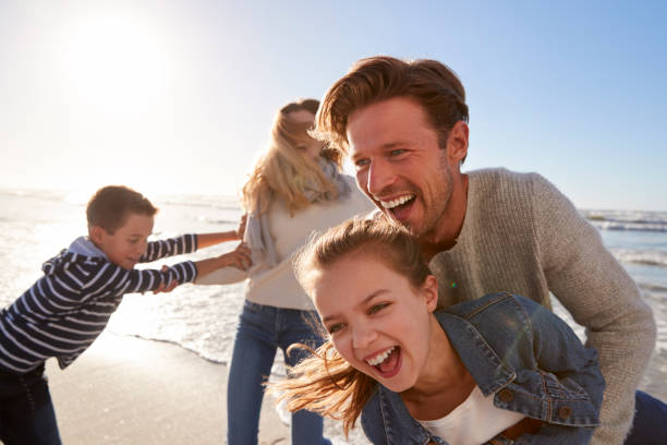 istock Parents With Children Having Fun On Winter Beach Together 935359732