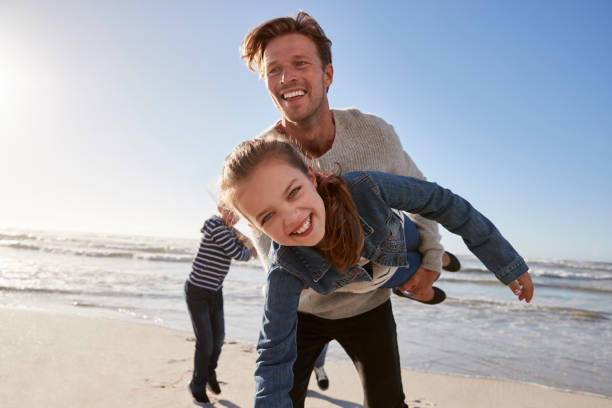 istock Father With Children Having Fun On Winter Beach Together 935359796