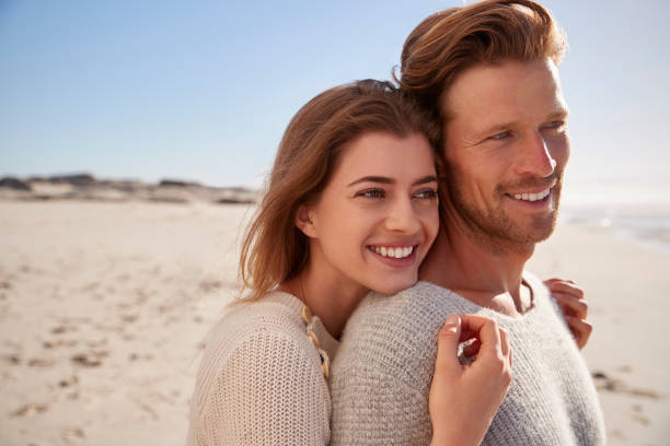istock Romantic Couple Embracing On Winter Beach 935360092