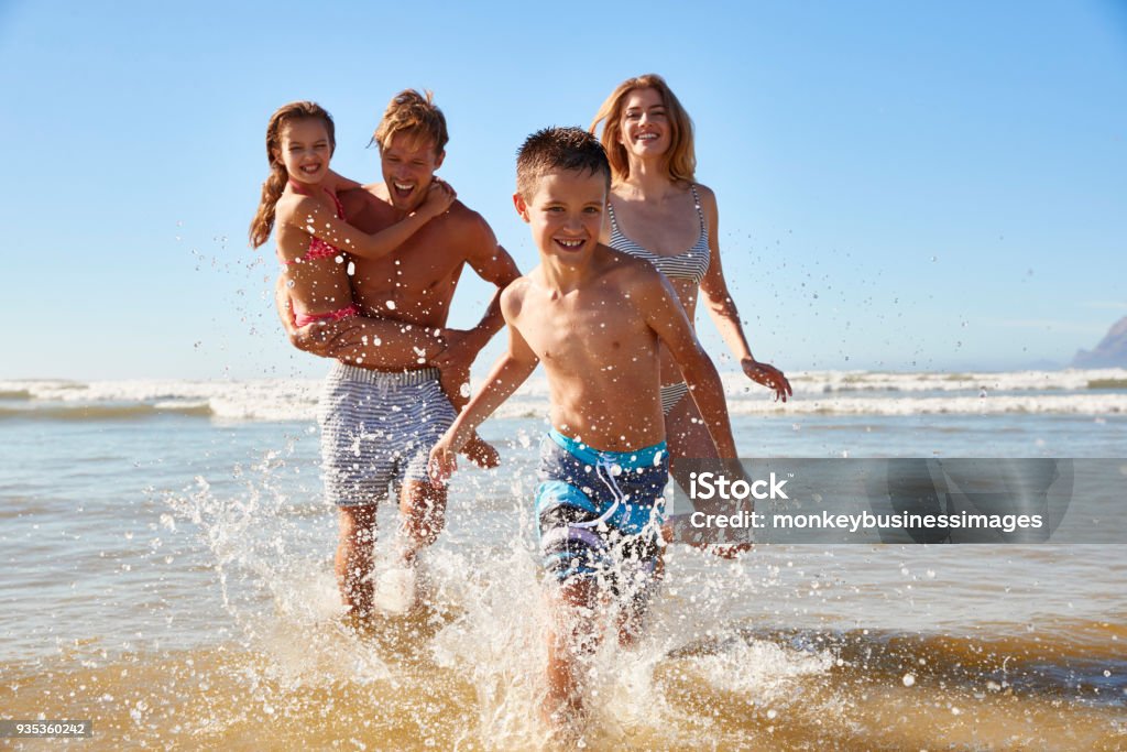 Familiar de vacaciones de verano playa de mar a la cámara de - Foto de stock de Familia libre de derechos