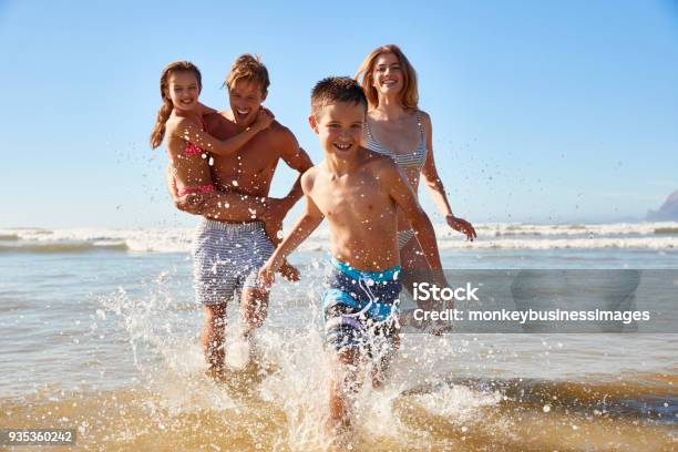 Familiar De Vacaciones De Verano Playa De Mar A La Cámara De Foto de stock y más banco de imágenes de Familia