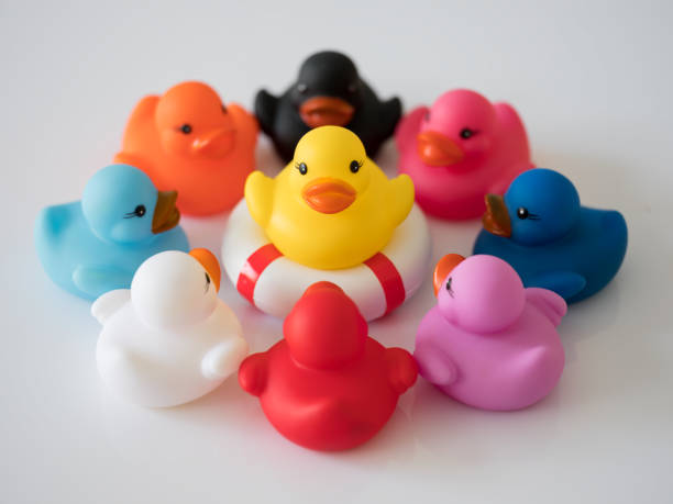 istock Group of nine different colored ducks in a circle facing each other, scene set on a white background. 935360414
