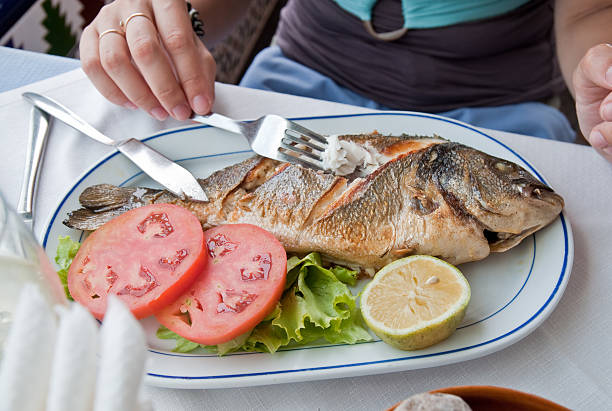 istock Grilled fish with tomatoes, lettuce, and lemon on a plate 93536783