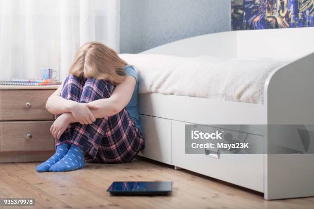 Sad Teenager Girl With Scales On Floor Stock Photo - Download Image Now - Teenage Girls, Bathroom, Bed - Furniture