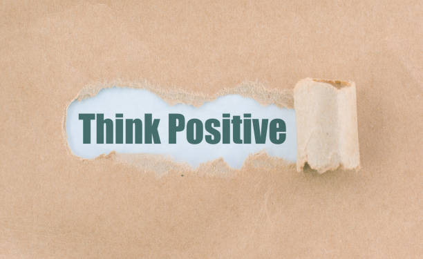 istock Letter Think Positive Written Behind Torn Paper 935380256