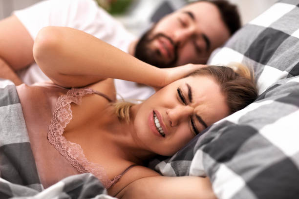 Adult couple suffering from snoring problem in bed stock photo