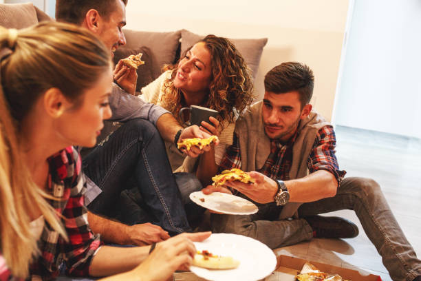 istock Group of young friends eating pizza. 935389528
