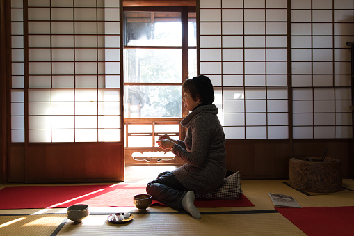 Japanese woman drinking matcha in traditional room