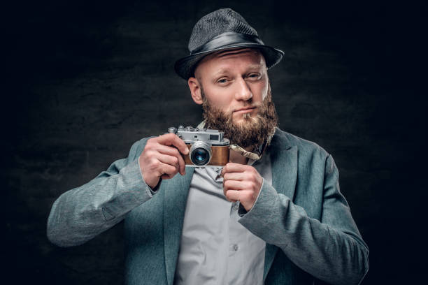istock A man dressed in a grey jacket and felt hat holds an SLR photo c 935400860