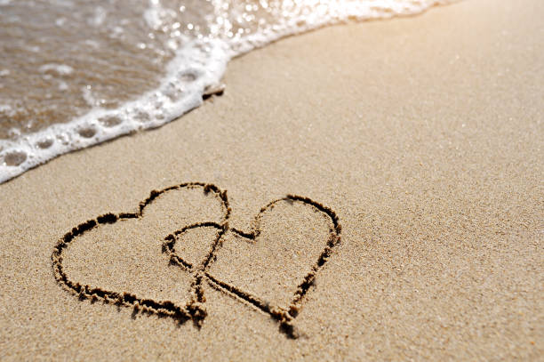 istock love concept - two hearts drawn on the beach sand 935402176