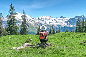 woman in a white hat is sitting on a meadow