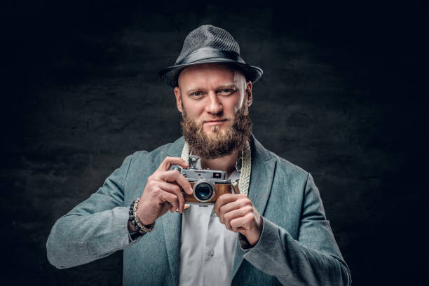 istock A man dressed in a grey jacket and felt hat holds an SLR photo c 935404804