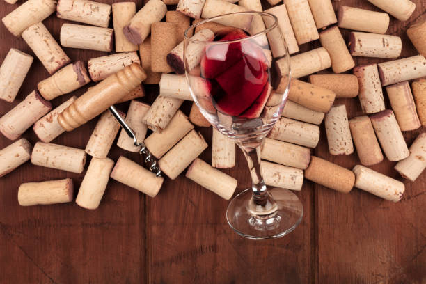 istock Glass of red wine with corks and corkscrew on a dark rustic background with copy space 935405372