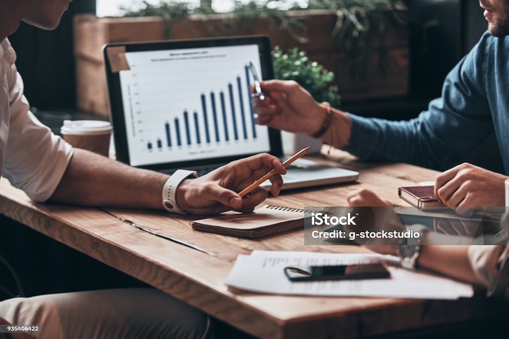 Checking the numbers. Close up of young business people analyzing data using computer while working in the office Analyzing Stock Photo