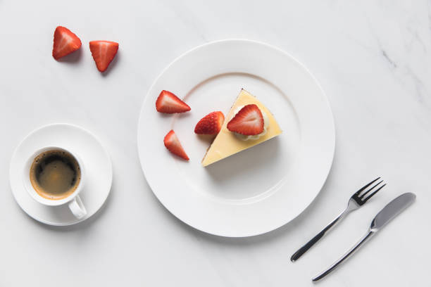 istock Top view of coffee cup with strawberry cheesecake on plate 935407720