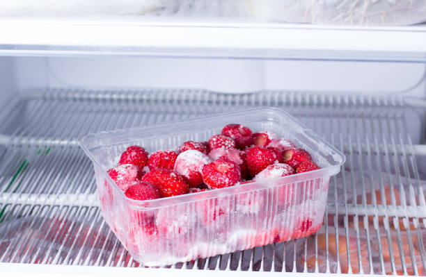 istock Frozen strawberries in a plastic container in the freezer 935411186