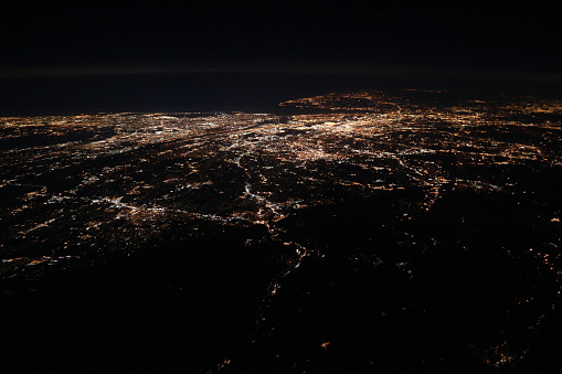 Picture taken inflight overhead New York, United States of America, showing New York City during night time.