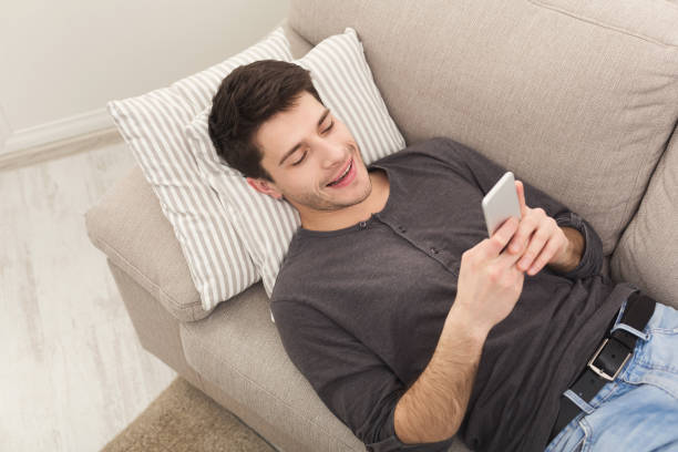 istock Young man messaging on smartphone at home 935415642