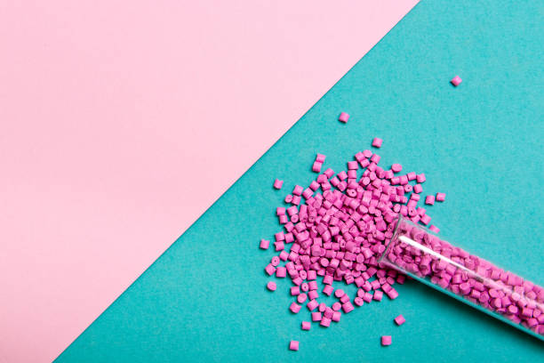 Plastic pellets . Plastic raw materials in granules for industry. Polymeric dye pink on a turquoise background. Plastic granules after processing of waste polyethylene and polypropylene.Polymer.