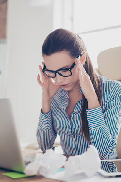 istock Overworked stressed young business lady is having headache and thinking how to end project. She is wearing strict shirt and glasses 935424454