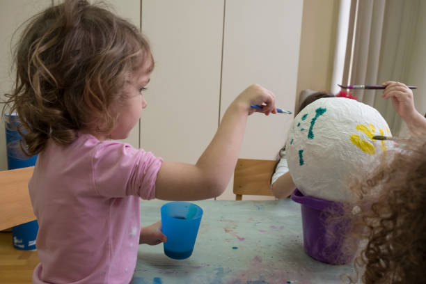 istock Creative children coloring Easter eggs at preschool 935428866
