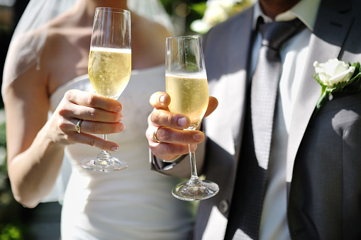 Bride and groom making a toast with champagne glasses after wedding ceremony